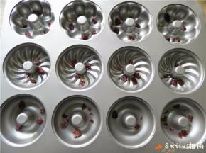 模具用毛刷蘸点玉米油刷模具，再分别撒入切碎的蔓越莓干。