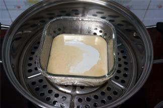 水沸腾后，将模具放入蒸锅里，然后倒一层黄糖粉浆，盖上锅盖，蒸5分钟。