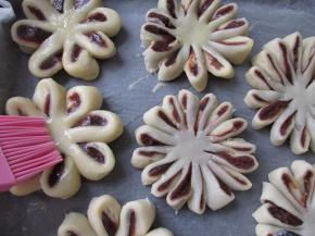 把做好的菊花酥胖到铺了锡纸的烤盘上，刷上蛋液，中间点入很芝麻。