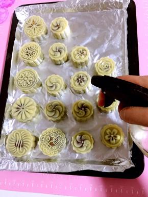 用喷壶在月饼生胚表面薄薄的喷一层水！以免烤的时候月饼表面裂开。