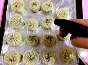 用喷壶在月饼生胚表面薄薄的喷一层水！以免烤的时候月饼表面裂开。