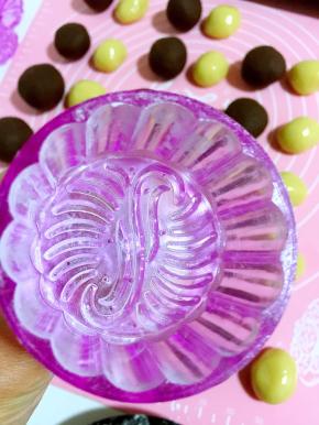 月饼模具在玉米淀粉中压一下，再轻轻的磕掉多余的粉！