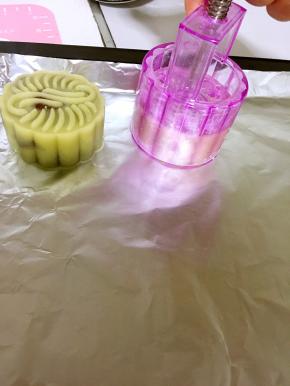月饼模具朝下按，稍微用力（力道要均匀哦！）把月饼生胚扣下来！
