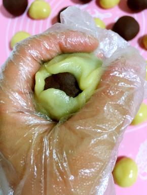 利用左手虎口慢慢向上推，把豆沙蛋黄馅儿包住！