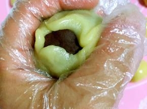 利用左手虎口慢慢向上推，把豆沙蛋黄馅儿包住！