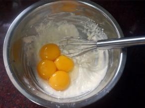 接着加入4个蛋黄，拌均匀，这就是酸奶蛋黄糊，备用。
