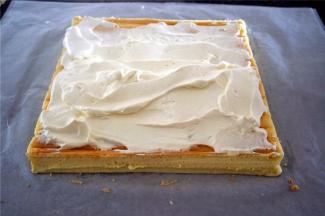 待蛋糕体冷却至温温的状态时，倾斜切去收尾，抹上打发好的淡奶油。