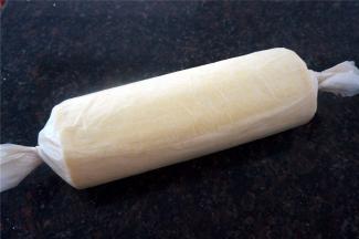 待蛋糕体冷却至温温的状态时，倾斜切去收尾，抹上打发好的淡奶油。