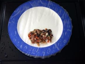 将圆形的春卷皮摊到碟子上，然后放上肉馅，像包班戟一样包起来