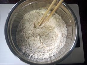 将325克高筋粉倒进深碗里，加入一个全蛋，2克食盐，用筷子搅拌一下。