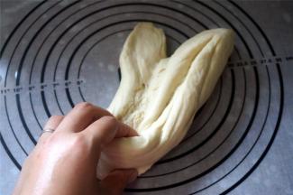 然后取出面团摔打20分钟左右。面团越摔打越有筋性，越摔打越顺滑。