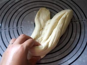 然后取出面团摔打20分钟左右。面团越摔打越有筋性，越摔打越顺滑。