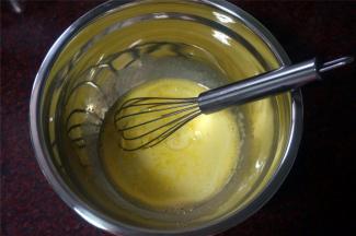 分离蛋白蛋黄后，取10克白砂糖加入到蛋黄的盆中，用手动打蛋器打至糖溶化后加入温热的牛奶，花生油（玉米油、调和油也可以）搅拌至完全混合。