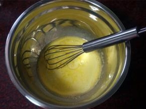 分离蛋白蛋黄后，取10克白砂糖加入到蛋黄的盆中，用手动打蛋器打至糖溶化后加入温热的牛奶，花生油（玉米油、调和油也可以）搅拌至完全混合。