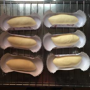 松弛好的面团擀成长舌状，从上往下卷成橄榄核的形状，捏紧收口，放入模具，或者不用模具也可以，直接放在油纸上