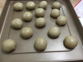 捏紧收口，整成圆形，将收口朝下摆放，排入烤盘