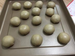 捏紧收口，整成圆形，将收口朝下摆放，排入烤盘