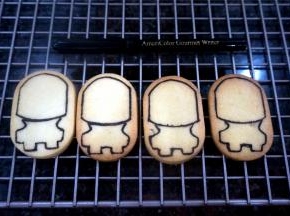 取4个椭圆形的饼干，用可食用色素笔绘画出小黄人的大致框架