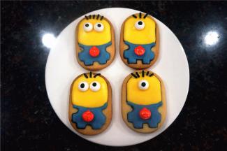 待主色晾干了六七成时，给小黄人粘上黑色的糖针做头发，并粘上小眼睛（单眼，双眼各两个），心口位置粘放入一个小南瓜糖珠