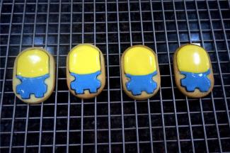 头部填上黄色糖霜，下身填上蓝色糖霜，填好色好放置一旁晾干约30分钟再继续。这个时候可以给其他卡通饼干填色，合理统筹时间