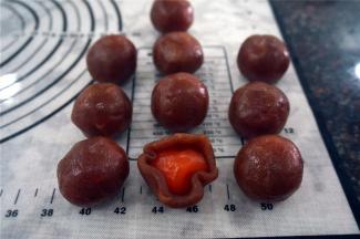 用红莲蓉包裹蛋黄，滚圆，备用。