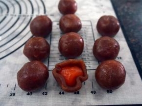 用红莲蓉包裹蛋黄，滚圆，备用。