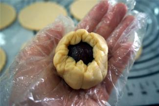 然后用酥皮包裹每一份馅料，往中间收紧口，收口朝下放置在无比派盘上。