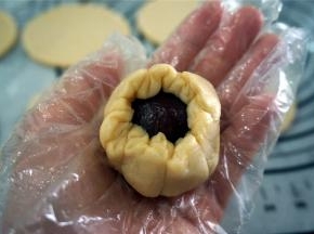 然后用酥皮包裹每一份馅料，往中间收紧口，收口朝下放置在无比派盘上。