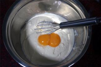 往芝士奶油糊里加入两个蛋黄，搅拌均匀。
