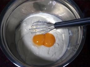 往芝士奶油糊里加入两个蛋黄，搅拌均匀。
