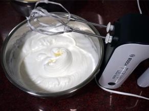 2个蛋白分两次加入共35克细砂糖，打发至大弯钩状态。