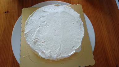 由于是大热天，除了开启冷气来做蛋糕外，淡奶油打发后也需要先冷藏半小时再用来装裱蛋糕。首先抹一层奶油。