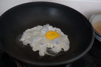 磕入鸡蛋，鸡蛋可以煎成糖心蛋或者全熟的，根据个人口味加入适量盐