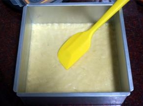 将面团平铺在方形模具里，用橡皮刮刀压平整或者手带手套后，用手推压平整。