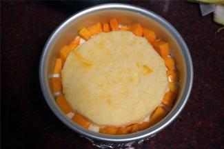 接着放入第二片蛋糕片，再四周的空隙以及蛋糕片上面均放上芒果肉粒。