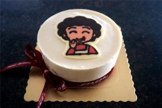 将丸子妈妈转印放置慕斯中央，四周围上慕斯围边，然后系上彩带。