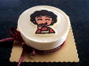 将丸子妈妈转印放置慕斯中央，四周围上慕斯围边，然后系上彩带。