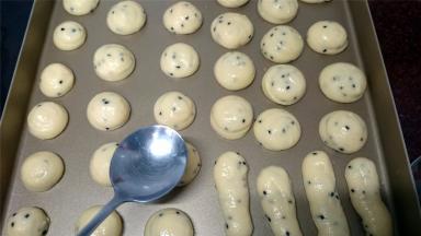 在烤盘上挤出约20克一个的小圆球，尖尖用勺子沾水压平。