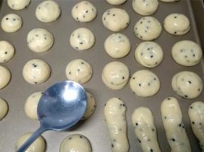 在烤盘上挤出约20克一个的小圆球，尖尖用勺子沾水压平。