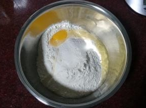 将高筋粉放入深盆中，打入一只鸡蛋，用筷子搅拌一下。