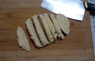 压面前先用刀将面团切成数片厚面片。