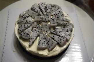 接着放上第二片蛋糕片，同样放上水果，填上奶油，抹平。