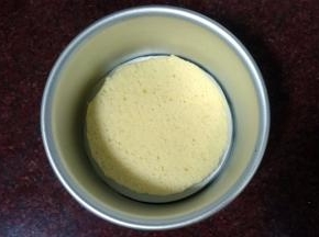 6寸的活底模具先垫上一张6寸的吸油纸，然后放入一片蛋糕片。