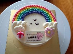 最后用白色淡奶油挤出云朵，用巧克力画出大雁，放上装饰糖花和礼物盒即可。