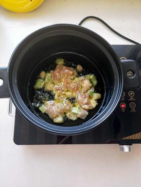 电陶炉启动煎烤健放砂锅家植物油，油温升起放入腌好的鸡肉翻炒，