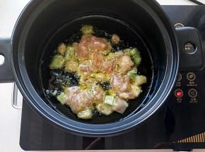 电陶炉启动煎烤健放砂锅家植物油，油温升起放入腌好的鸡肉翻炒，