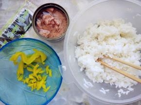 米饭加少许寿司醋和芝麻拌匀，金枪鱼罐头沥净汤汁，捣碎。海苔剪碎，腌萝卜剪碎