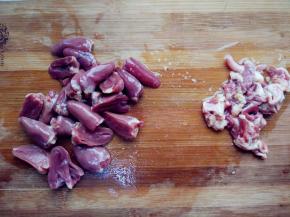 用刀将鸡心的脂肪刮掉，并切去顶部的心管，对半切成两块，用流动的水冲净内部的淤血块。