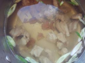 锅中倒入高汤、水和少许油，加少许盐、十三香、葱花和羊肉，大火煮开后，撇去浮沫，把羊肉炖软烂