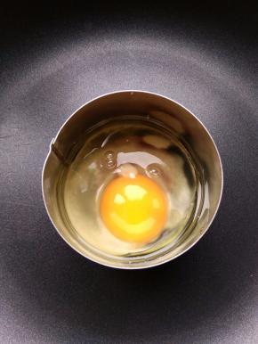 热锅热油，讲一个鸡蛋打进圆形模具中，小火加热。也可以提前将鸡蛋打散，蛋液中混少许盐，再倒入模具中煎。